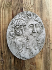 Wall ornament stone round, with an image of the cheerful oak leaf man, forest spirit.