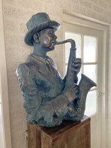 Beautiful torso of a jazz musician with saxophone in green-gold