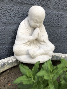 Shaolin Monk sitting praying, full of stone