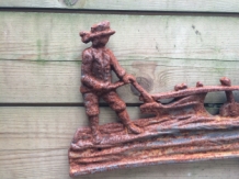 Wall decoration , cast iron fireplace plate farmer with horse and plow.