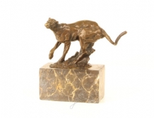 A bronze statue/sculpture of a running puma