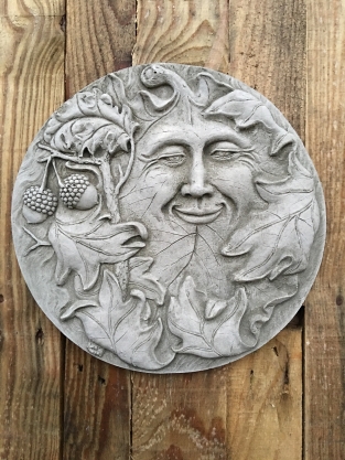 Wall ornament stone round, with an image of the cheerful oak leaf man, forest spirit.