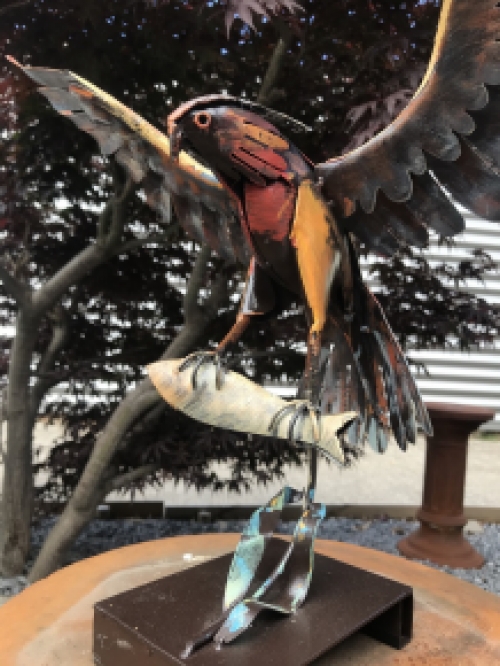 Ein Metallkunstwerk eines Adlers, der einen Fisch fängt, ''IRON EAGLE''.