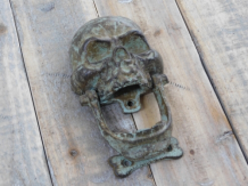 Cast iron green-brown skull as a door knocker.