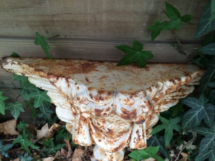 Wall angel as a supporting console made of cast iron in the color white/rust.