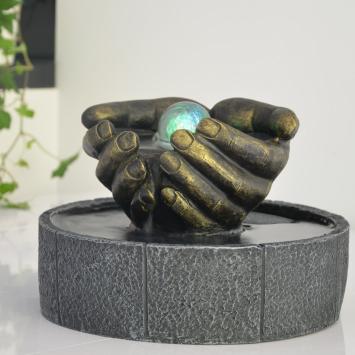 Indoor fountain, hands as bowl, illuminated water ornament