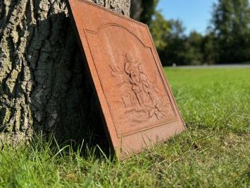 Antique hearth plate with old scene, vintage cast iron, rustic