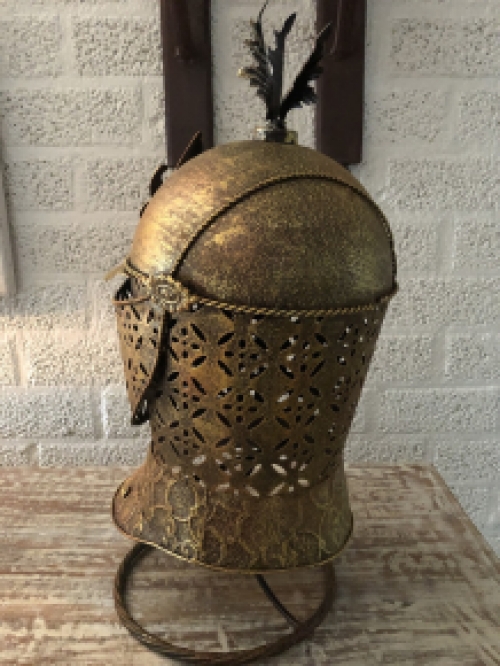 A beautiful metal brass knight helmet on stand.