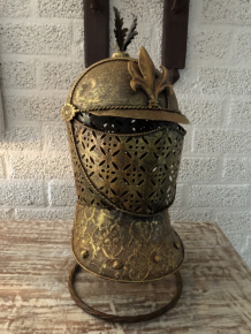 A beautiful metal brass knight helmet on stand.