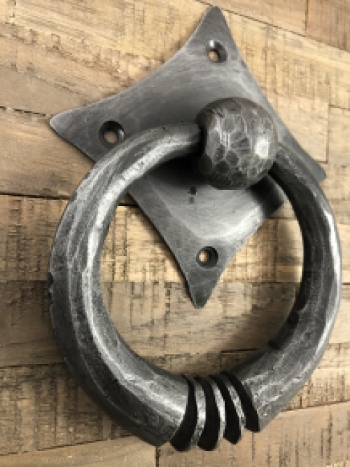 Pull-ring - door knocker wrought iron for on the rustic wooden door, convent door, country house door.