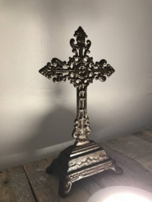 A cross on a stand made of cast iron