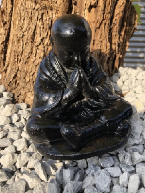 Shaolin Monk sitting praying, full of stone black