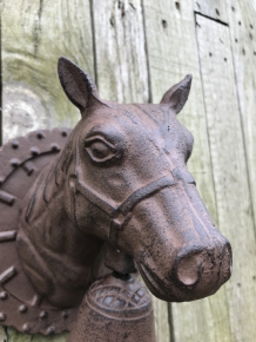 Een mooie deurbel met paardenhoofd gevestigd op een fraaie achtergrond, heel leuk!