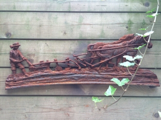 Wall decoration , cast iron fireplace plate farmer with horse and plow.