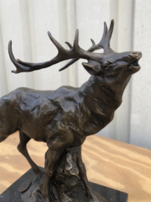 A bronze statue/sculpture of a deer