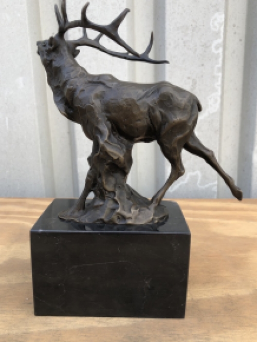 A bronze statue/sculpture of a deer